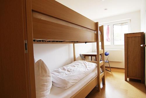 a bedroom with two bunk beds and a desk at Haus Rena am Südstrand in Borkum