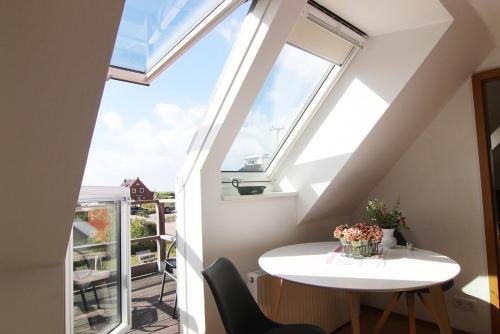 a small room with a white table and a window at Haus Rena am Südstrand in Borkum