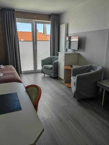 a room with two chairs and a couch and a table at Hotel Passat in Borkum