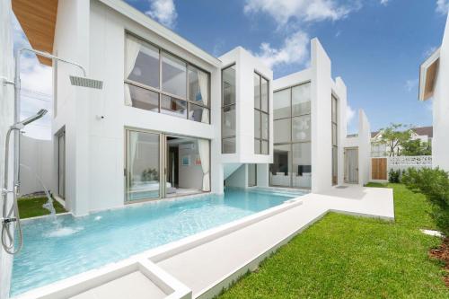 an exterior view of a house with a swimming pool at Exclusive Living in Designer 4BR Pool Villa in Lux Pride 2 V11 Residence, Near Laguna in Bang Tao Beach