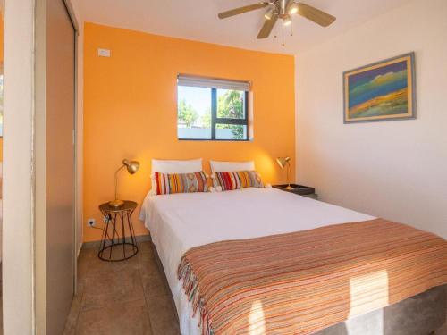 a bedroom with a bed with an orange wall at Cape Town 4U Guesthouse in Cape Town