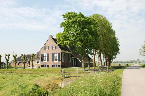 a house on the side of a field next to a road at Safari tent Heeg 4 persons in Heeg