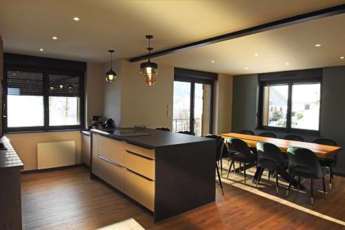 une cuisine et une salle à manger avec une table et des chaises dans l'établissement Chez Mimile , au calme , proche centre , wifi, à La Bresse