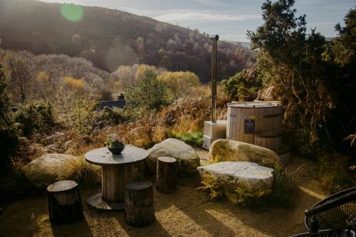 a table and some rocks and a table and a barrel at The Deerstone Luxury Eco Hideaway in Laragh