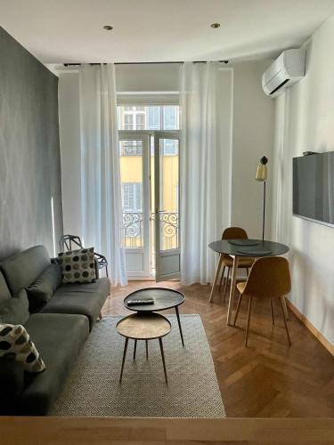 un salon avec un canapé et une table dans l'établissement Superbe Appartement au Cœur de Nice, à Nice