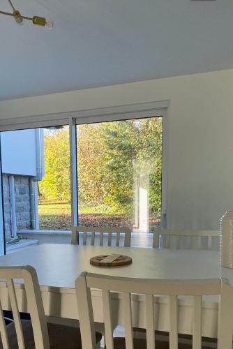 une salle à manger avec une table et des chaises et une fenêtre dans l'établissement Le Cocon des Lacs, à Clairvaux-les-Lacs