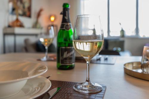 a glass of wine sitting on a table with a bottle of wine at Harbour Loft 1G in Kamperland