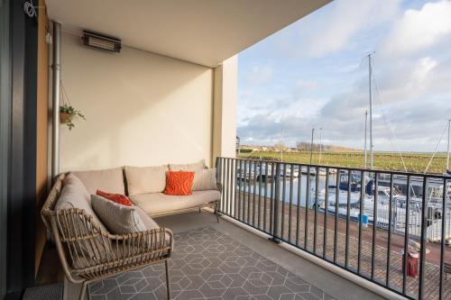 a balcony with a couch and a view of a harbor at Harbour Loft 1G in Kamperland