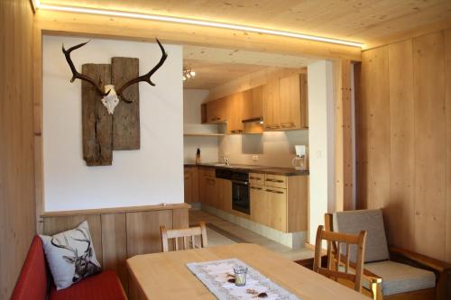 a dining room with a table and a deer head on the wall at Apartment Urstöger in Gosau