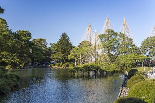 a view of a river in a park with trees at HOTEL AO Kanazawa in Kanazawa