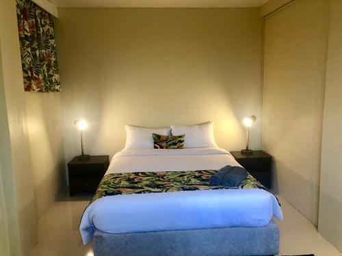 um quarto com uma cama grande com duas lâmpadas em Kidsfirst Apartment 1 - Duncan Road Suva em Suva