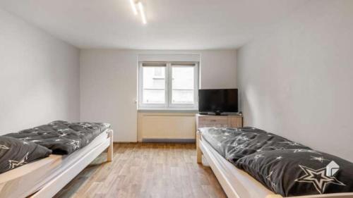 two beds in a room with a window at Große Ferienwohnung mitten in Bad Belzig in Bad Belzig