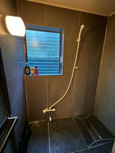 a shower in a bathroom with a window at 箱根 星那 箱根中心 神社 海賊船徒歩圏 in Hakone