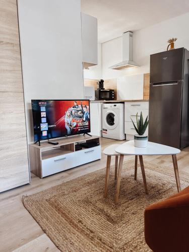 - un salon avec une table et une télévision dans l'établissement Studio Cosy - Balcon - Wifi - Free parking, à Narbonne