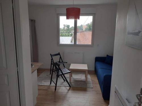 un salon avec un canapé bleu et une chaise dans l'établissement Studio 16m2 equipé, à Nantes