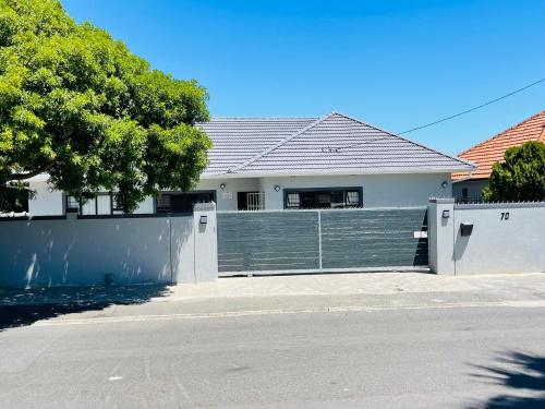 a white house with a fence in front of it at Maita Guest in Cape Town