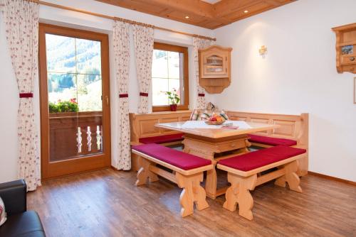 a kitchen with a table and benches and a window at Chalet Innertal in Inneralpbach
