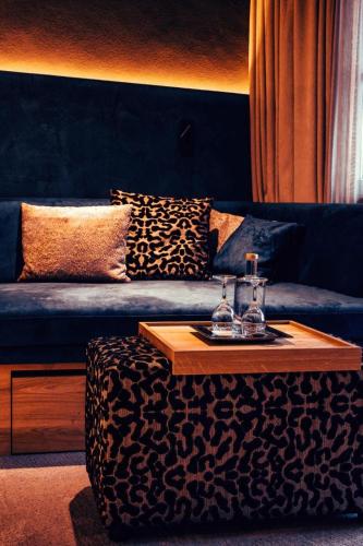 a living room with a blue couch and a table at Hotel Alpenkönig in Oberstaufen