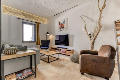 un salon avec un canapé et une télévision dans l'établissement La Remise des Amis - Proche du centre du village, à Peyriac-de-Mer