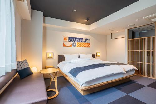 a bedroom with a large bed and a table at -SPA RESORT- Nagoya Kasadera Hotel in Nagoya