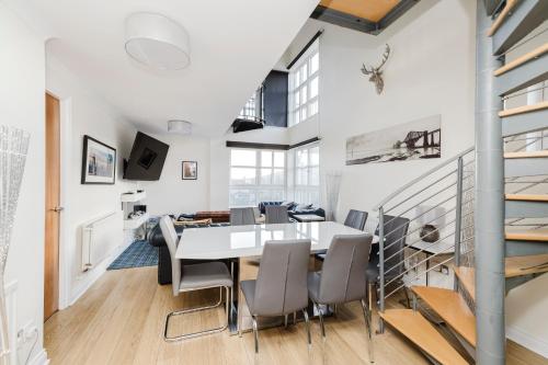 a dining room with a white table and chairs at JOIVY Stylish 3 bed, 3 bath flat with Balcony in Old Town in Edinburgh