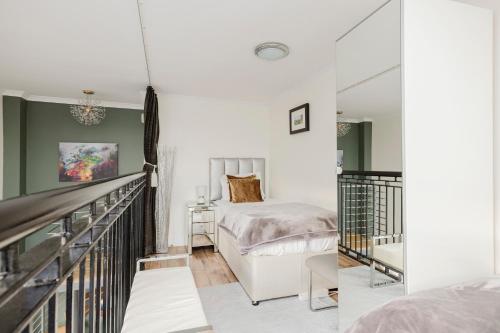 a bedroom with a bed and a staircase at JOIVY Stylish 3 bed, 3 bath flat with Balcony in Old Town in Edinburgh