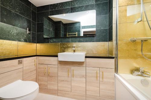 a bathroom with a toilet and a sink and a tub at JOIVY Stylish 3 bed, 3 bath flat with Balcony in Old Town in Edinburgh
