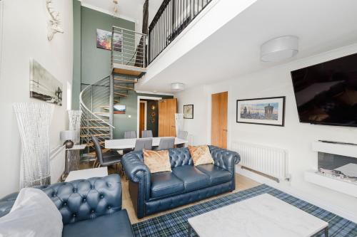 a living room with a couch and a staircase at JOIVY Stylish 3 bed, 3 bath flat with Balcony in Old Town in Edinburgh