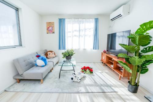 a living room with a couch and a tv at Free parking for compact cars 4 minutes walk from Kawaguchi Newly built three-story single-family house with 78 square meters 18 minutes by train to Ueno in Kawaguchi