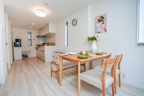 a kitchen and dining room with a wooden table and chairs at Free parking for compact cars 4 minutes walk from Kawaguchi Newly built three-story single-family house with 78 square meters 18 minutes by train to Ueno in Kawaguchi