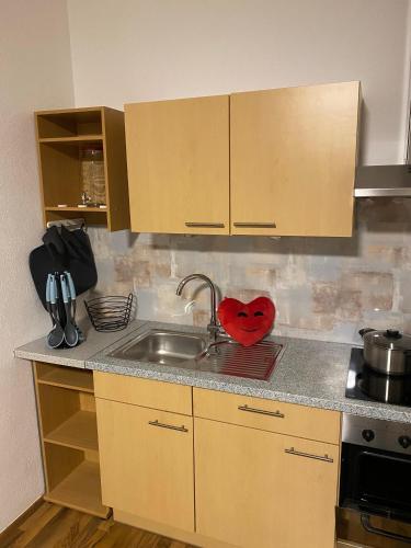 a kitchen with a sink and a red heart on the counter at Ferienwohnung Delja in Aulendorf