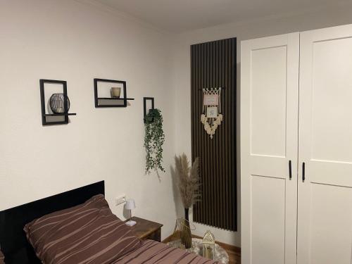 a bedroom with a bed and a white wall at Ferienwohnung Delja in Aulendorf