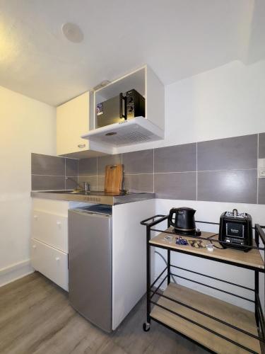 une petite cuisine avec une table et un micro-ondes dans l'établissement Dionysos, à Caen