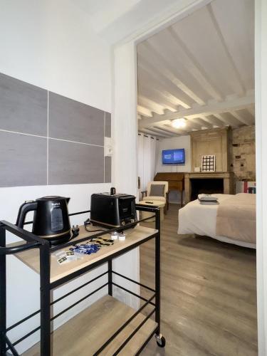 une chambre avec un lit et une table avec un micro-ondes dans l'établissement Dionysos, à Caen