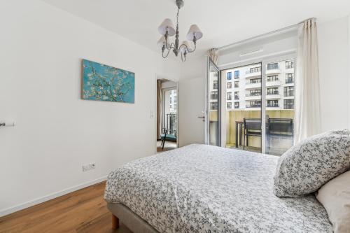 une chambre blanche avec un lit et une fenêtre dans l'établissement Cours des Lavandières - Joli T2 proche Paris, à Saint-Ouen