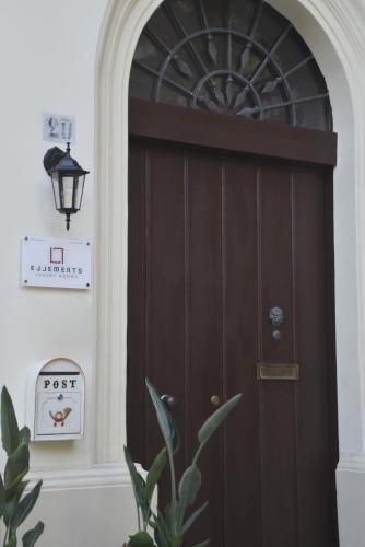 a brown door in a room with a clock at ELLEMENTS - Luxury Rooms in Brindisi