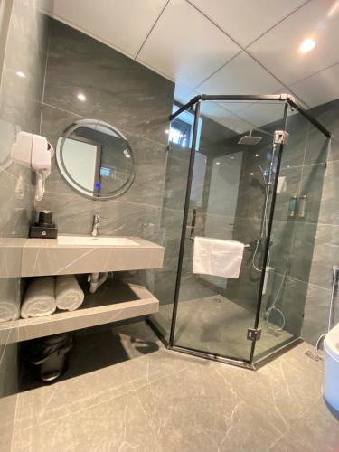 a bathroom with a shower and a sink and a mirror at Kings Villa in Gio Nhan