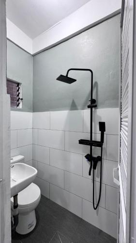 a white bathroom with a toilet and a sink at Bangketa Apartments in Antipolo