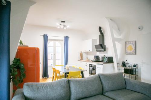 a living room with a couch and a table at Le Magnolia - A 10 minutes de Disneyland in Lagny