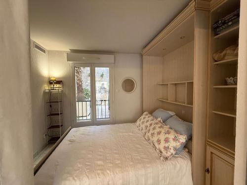 une petite chambre avec un lit et une fenêtre dans l'établissement B051-Bel appartement au centre deux chambres et parking securise, à Cannes