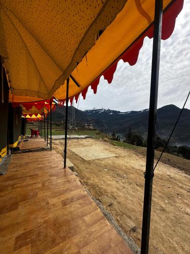 a row of umbrellas on top of a building at Adiyogi Campsite in Sari
