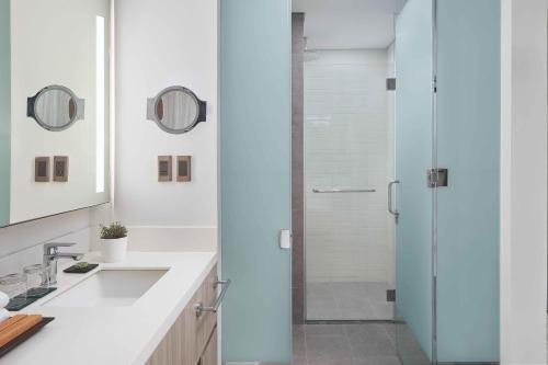 a bathroom with a glass shower and a sink at Lanson Place Mall of Asia Manila in Manila