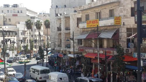 a busy city street with cars and people on the street at Cliff Hostel in Amman
