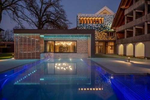a swimming pool in front of a building at night at Hotel am Haslinger Hof in Bad Füssing
