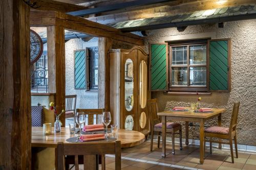 a dining room with two tables and chairs and windows at Hotel am Haslinger Hof in Bad Füssing