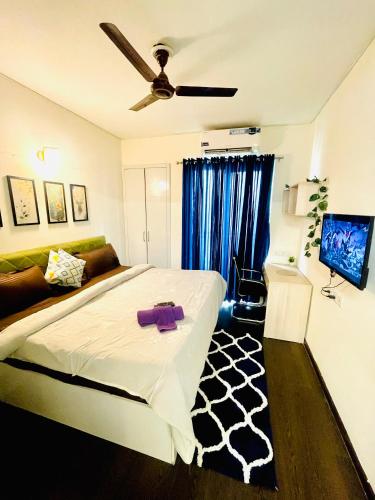 Un dormitorio con una cama y un ventilador de techo. en Blues - Aashray, en Noida