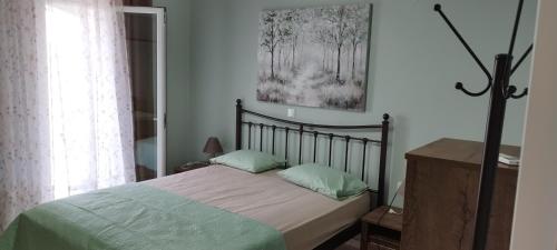 a bedroom with a bed and a picture on the wall at Loukas House 1Σταυρος-Κερκυρα Μακράτα in Stavrós