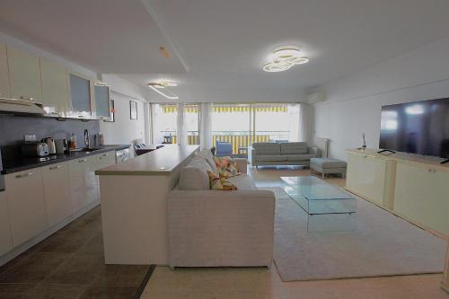 une cuisine et un salon avec un canapé et une table dans l'établissement Cannes Palm Beach - Fully fitted apartment - 2 bedrooms, à Cannes