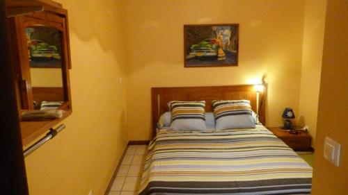 1 dormitorio con 1 cama con colcha a rayas en Lodge Takini 4, en Kourou