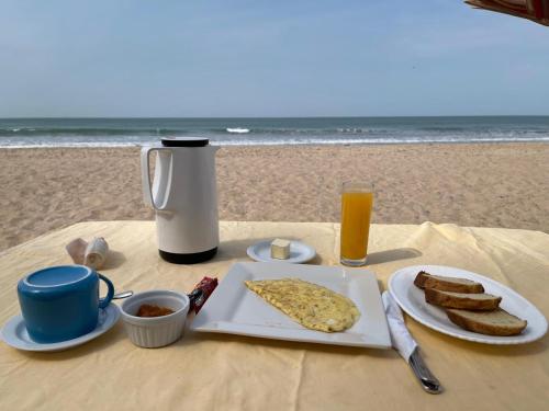 a table with a plate of food with toast and a drink at Poco Loco B&B in Abene